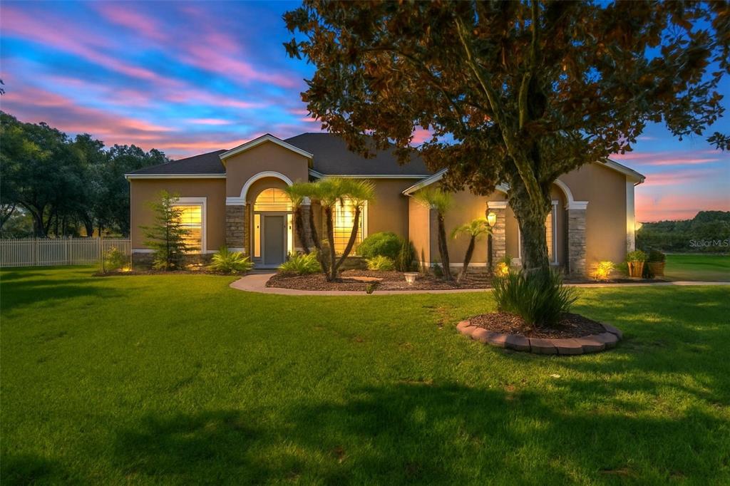 A single-story house with a tan stucco exterior, stone accents, and a landscaped front yard — 209 FOREST BREEZE AVENUE, BRANDON, FL