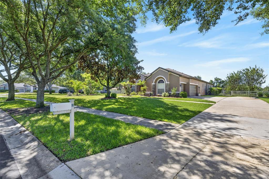 A single-story house with a tan exterior, stone accents, and a concrete driveway — 209 FOREST BREEZE AVENUE, BRANDON, FL