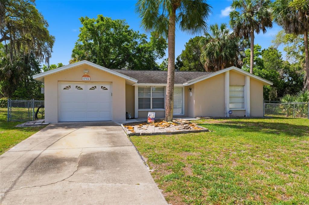 A single-story house with a beige exterior, a one-car garage, and a concrete driveway — 8704 LONG BOAT LANE, HUDSON, FL