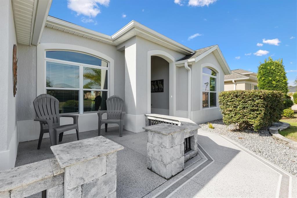 A light-colored house exterior features a front porch with two chairs and stone pillars — 3461 EARL WAY, THE VILLAGES, FL