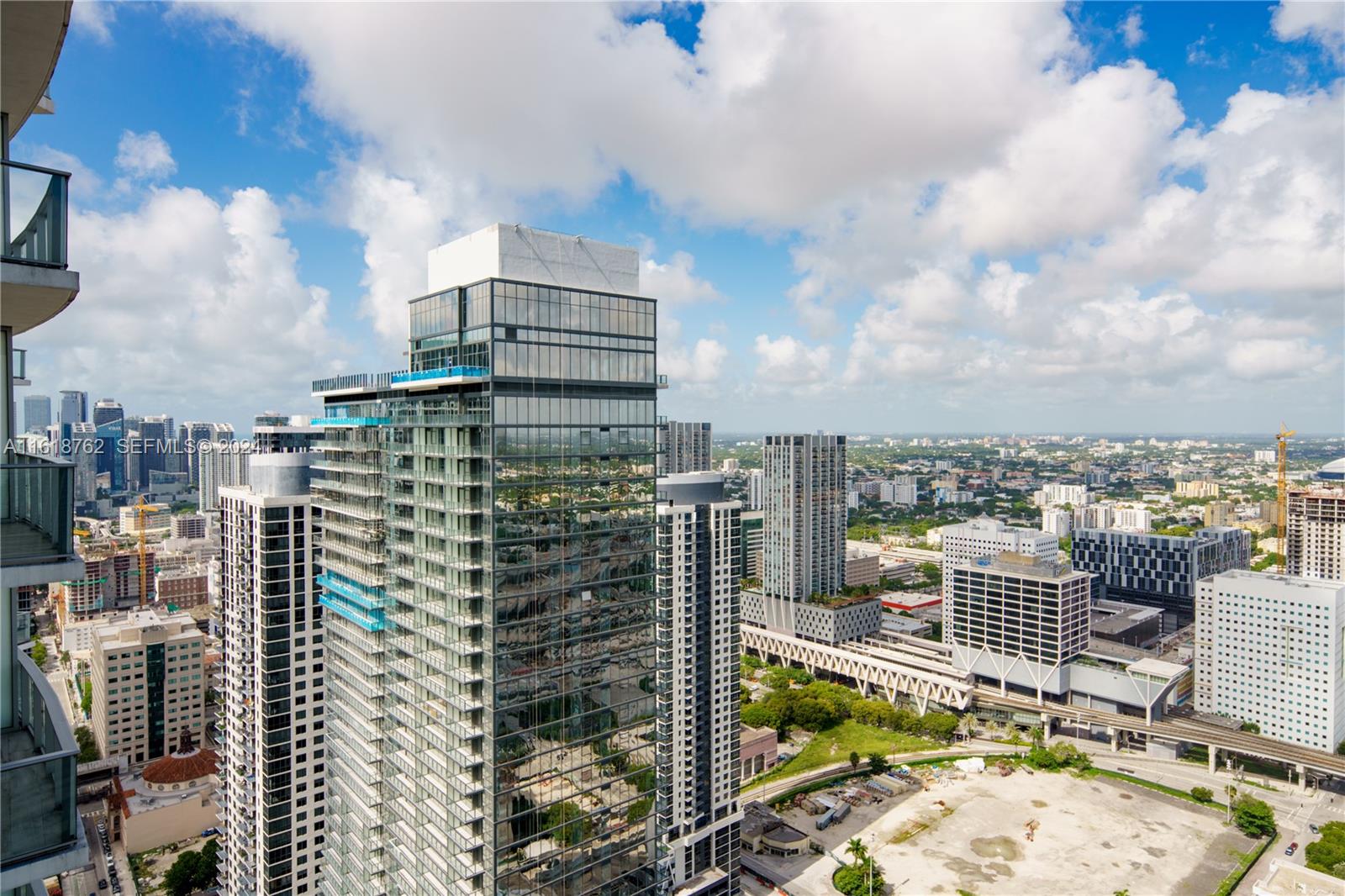An elevated view of a modern glass skyscraper surrounded by other high-rise buildings in Miami — 851 NE 1st Ave # 4406, Miami FL 33132, MIAMI, FL