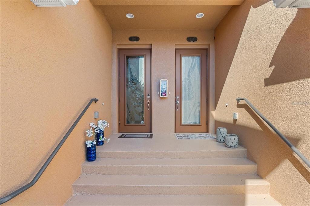 A concrete staircase leads to two adjacent front doors with glass panels under a portico — 416 WINDING BROOK LANE UNIT 102, BRADENTON, FL