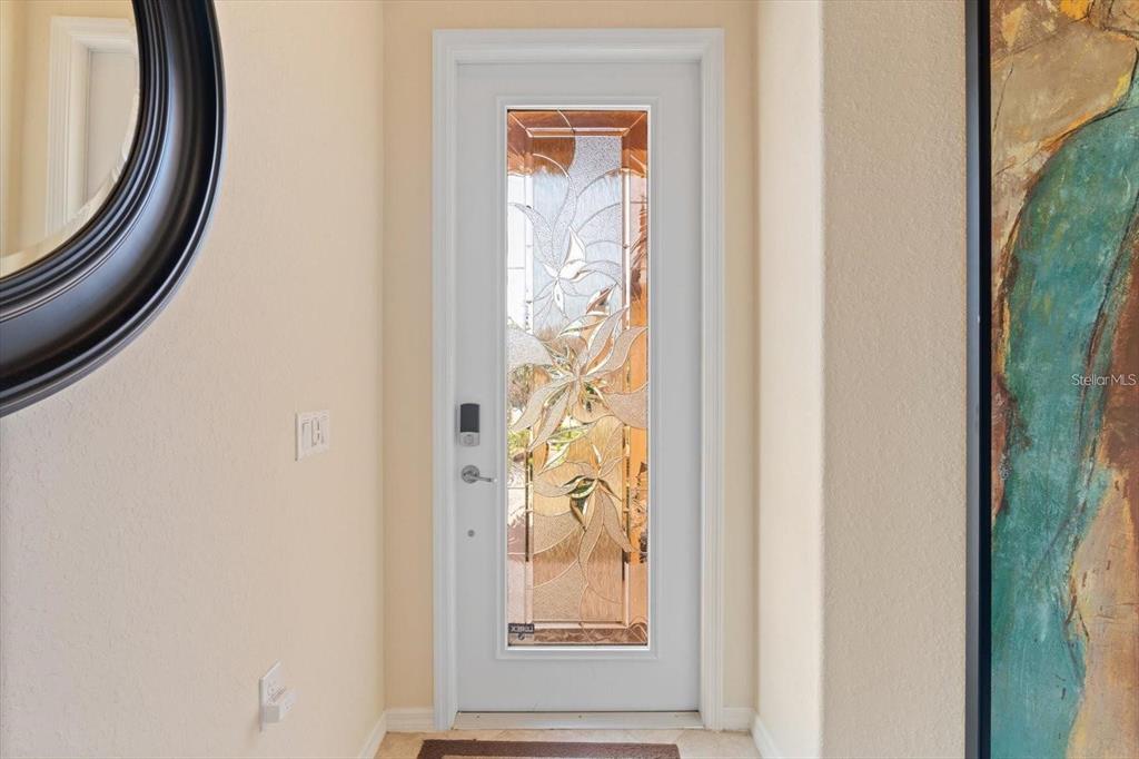 A white front door with a decorative glass insert sits between two interior walls — 416 WINDING BROOK LANE UNIT 102, BRADENTON, FL