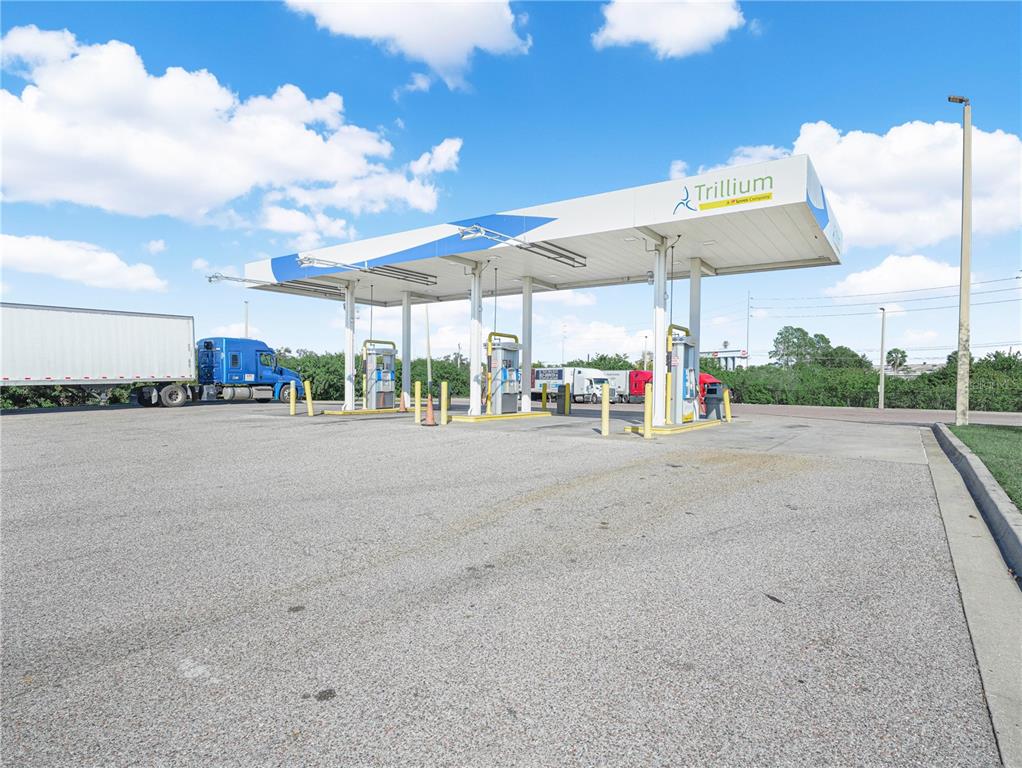 A Trillium fueling station canopy stands over multiple gas pumps in a paved parking lot — 5030 MADISON AVENUE, TAMPA, FL