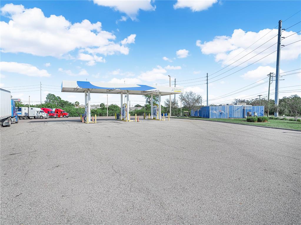An outdoor fueling station features a white canopy with blue accents and parked semi-trucks — 5030 MADISON AVENUE, TAMPA, FL