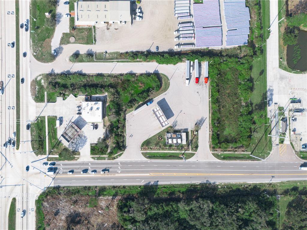 An aerial view shows a commercial property with a building, parking lot, and truck trailers — 5030 MADISON AVENUE, TAMPA, FL