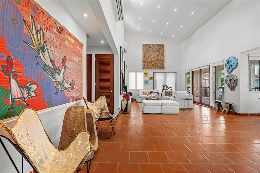 A spacious living room with terracotta tile floors, high ceilings, and large abstract wall art — . LAKESIDE VILLAS UNIT D4, VEGA ALTA, PR