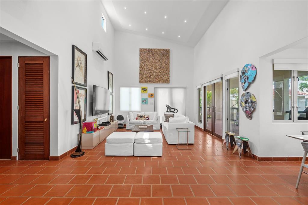 A living room with white walls, vaulted ceilings, terracotta tile floors, and modern furniture — . LAKESIDE VILLAS UNIT D4, VEGA ALTA, PR