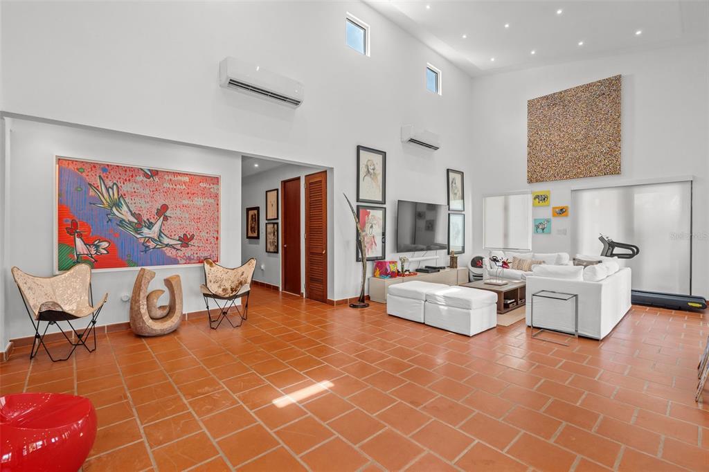 A spacious living room with high ceilings, white furniture, and terracotta tile flooring — . LAKESIDE VILLAS UNIT D4, VEGA ALTA, PR