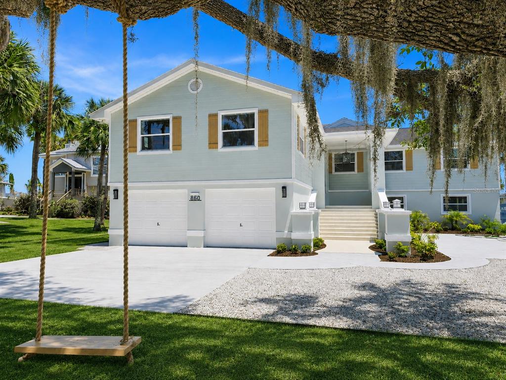 A light blue two-story house with a two-car garage and a front yard swing — 860 LAMBERT AVENUE, FLAGLER BEACH, FL