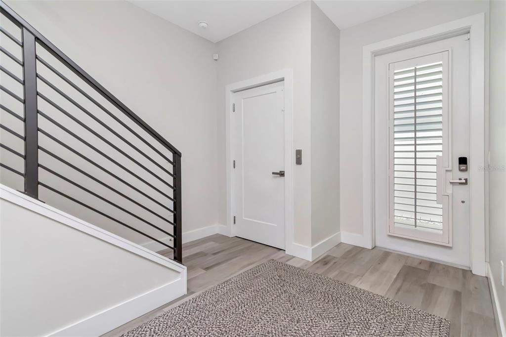 A modern kitchen features light gray cabinetry, a white quartz island, and wood flooring — 536 4TH AVENUE S UNIT 2, ST PETERSBURG, FL