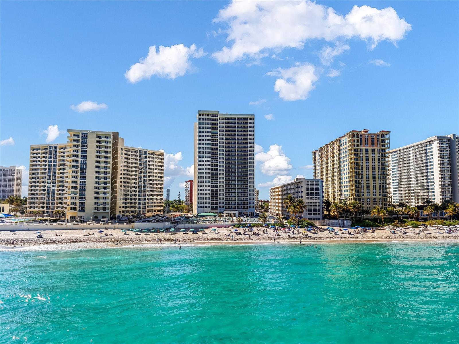An aerial view of several high-rise residential buildings situated directly along a sandy beach — 3140 S Ocean Drive # 208, Hallandale Beach FL 33009, HALLANDALE BEACH, FL