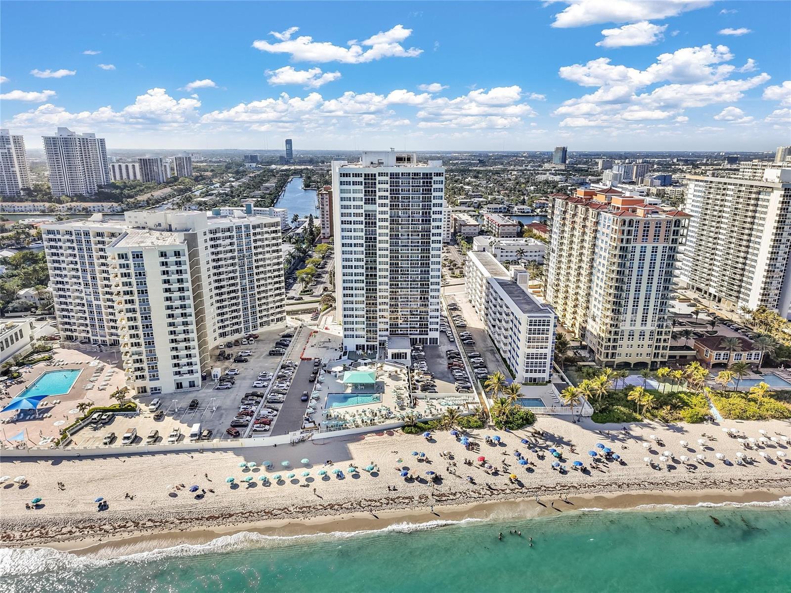 An aerial view shows several high-rise apartment buildings situated directly on a sandy beach — 3140 S Ocean Drive # 208, Hallandale Beach FL 33009, HALLANDALE BEACH, FL