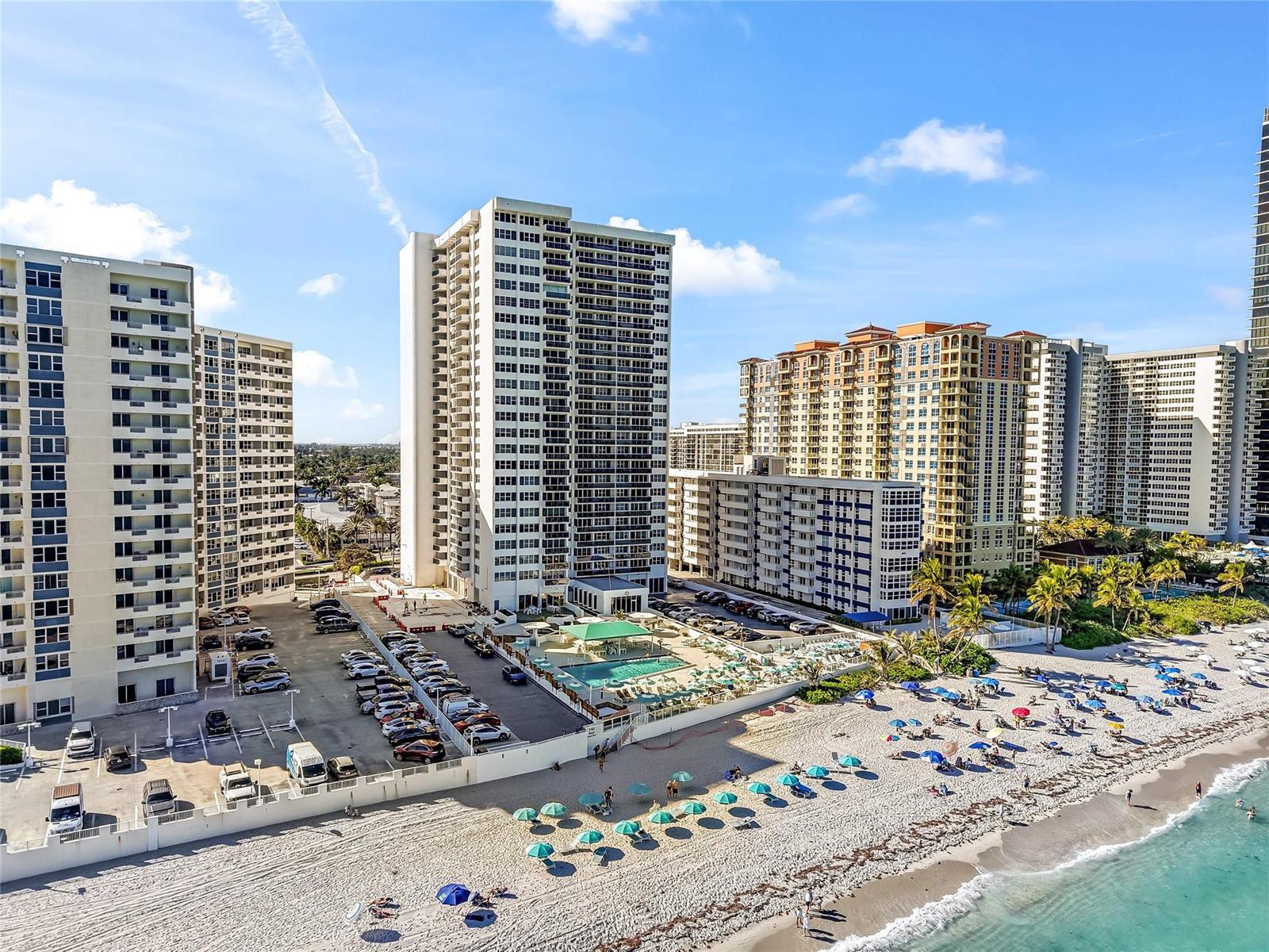 An aerial view shows high-rise apartment buildings, a parking lot, a swimming pool, and beach — 3140 S Ocean Drive # 208, Hallandale Beach FL 33009, HALLANDALE BEACH, FL