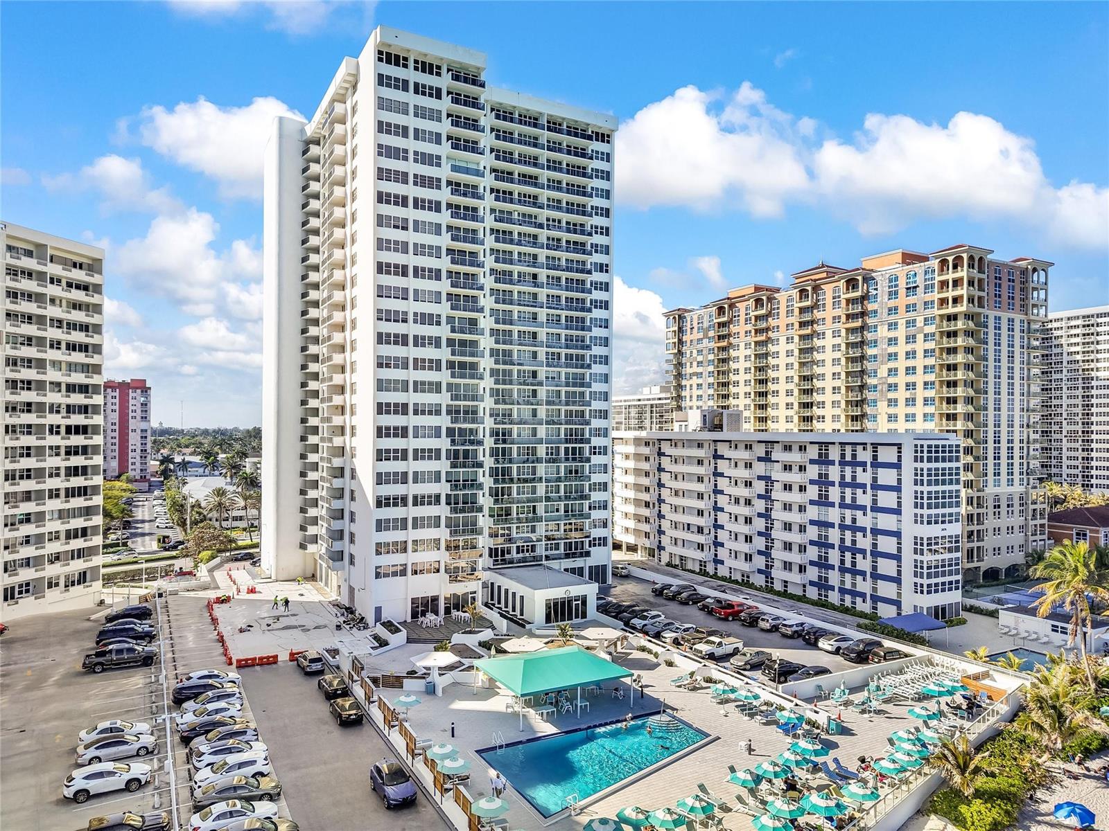 An aerial view shows a tall residential building with a pool and parking lot — 3140 S Ocean Drive # 208, Hallandale Beach FL 33009, HALLANDALE BEACH, FL
