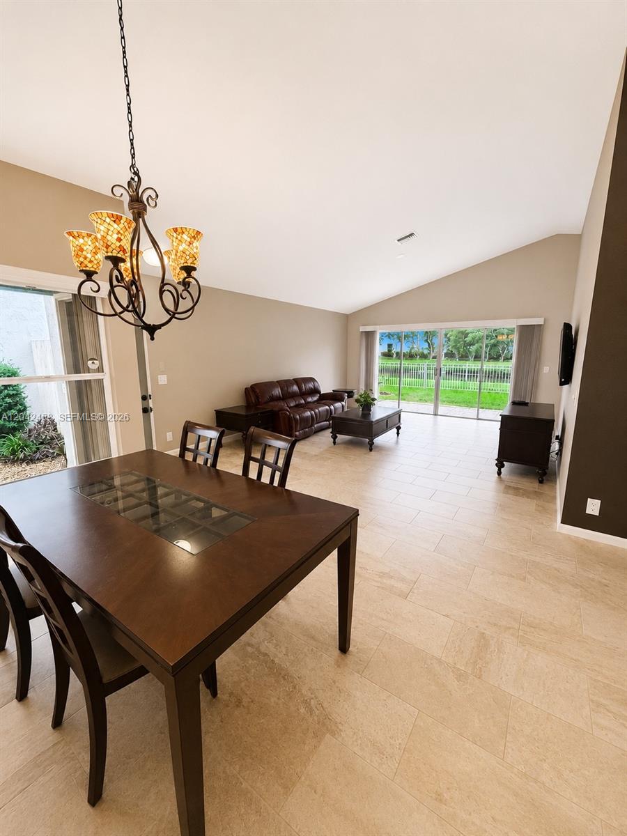 A dining area with a chandelier flows into a living room featuring tile floors — 10750 NW 10th St, Plantation FL 33322, PLANTATION, FL