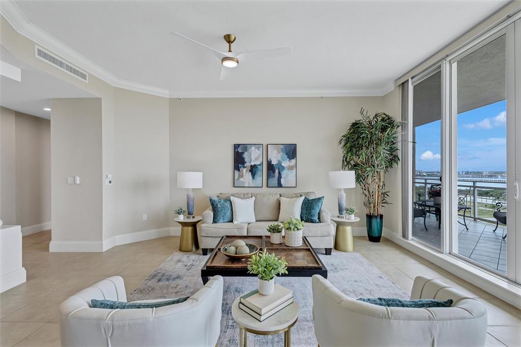 A living room features a beige sofa, two white armchairs, a coffee table, and balcony access — 130 RIVIERA DUNES WAY UNIT 804, PALMETTO, FL