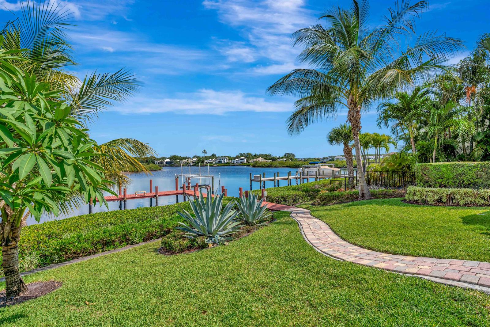 A paved walkway leads through a grassy yard toward a private boat dock on the water — 102 Victory Drive, Jupiter FL 33477, JUPITER, FL