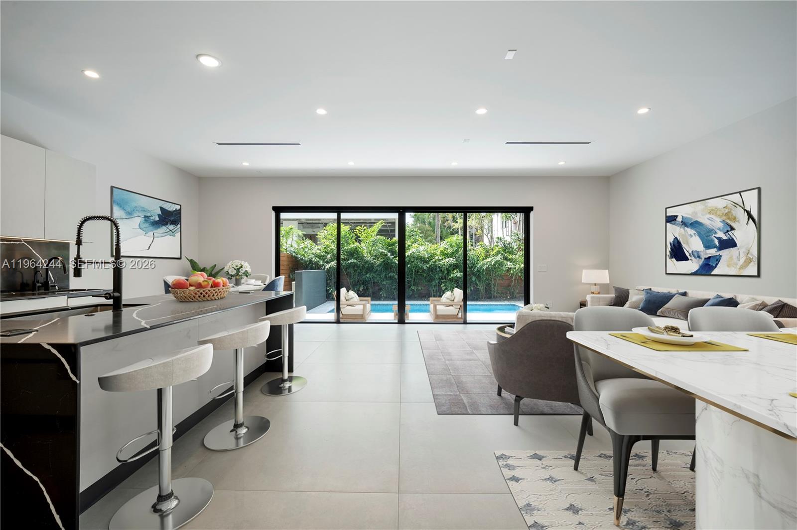 A modern open-concept kitchen and living area features a pool view through sliding glass doors — 2962 W Trade Ave, Coconut Grove FL 33133, COCONUT GROVE, FL