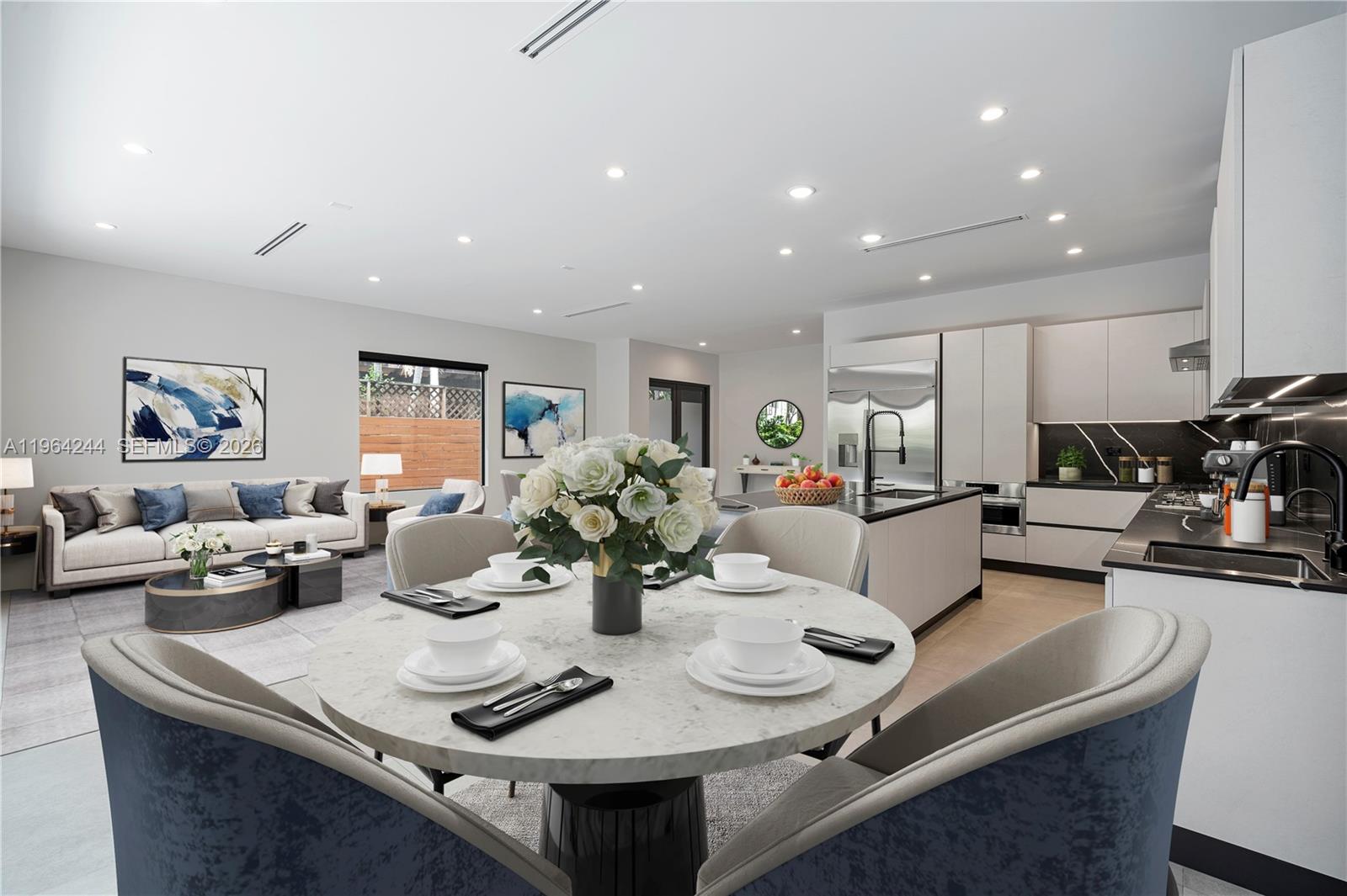 An open-concept living and dining area features a round marble table and a modern kitchen — 2962 W Trade Ave, Coconut Grove FL 33133, COCONUT GROVE, FL