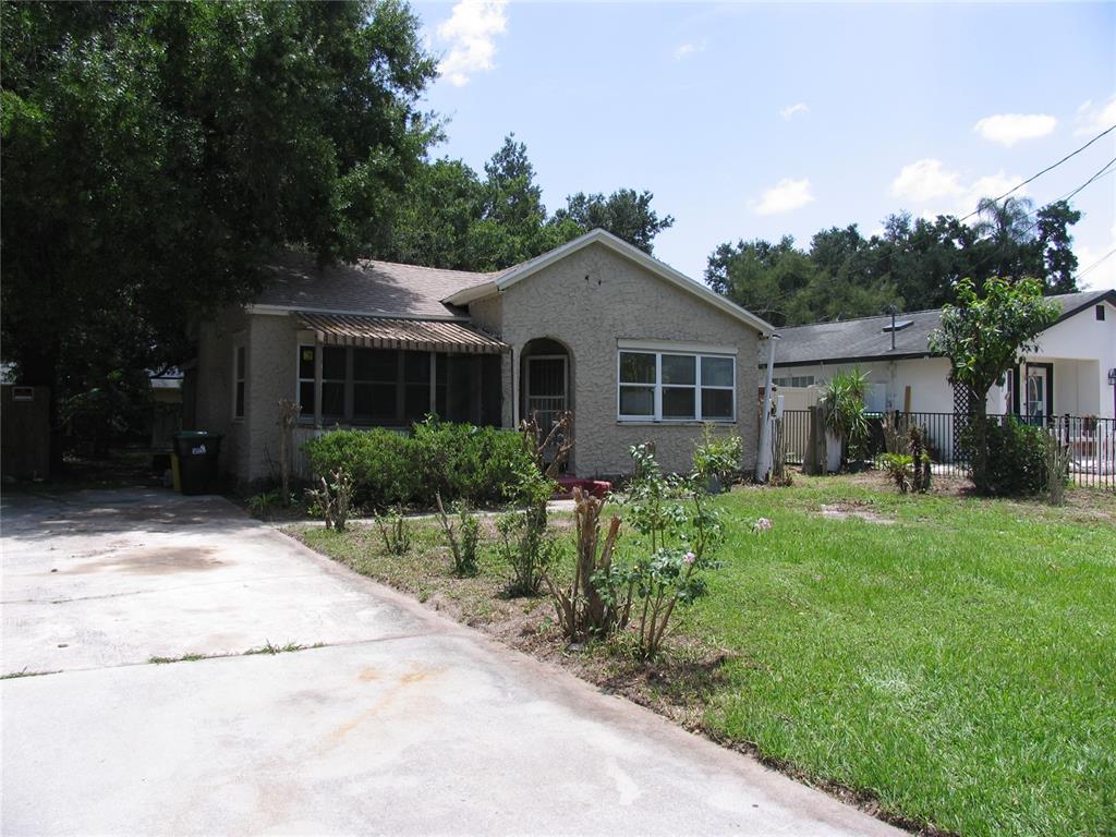 A single-story house with a stucco exterior, a front porch, and a concrete driveway — 323 DOVER STREET, ORLANDO, FL