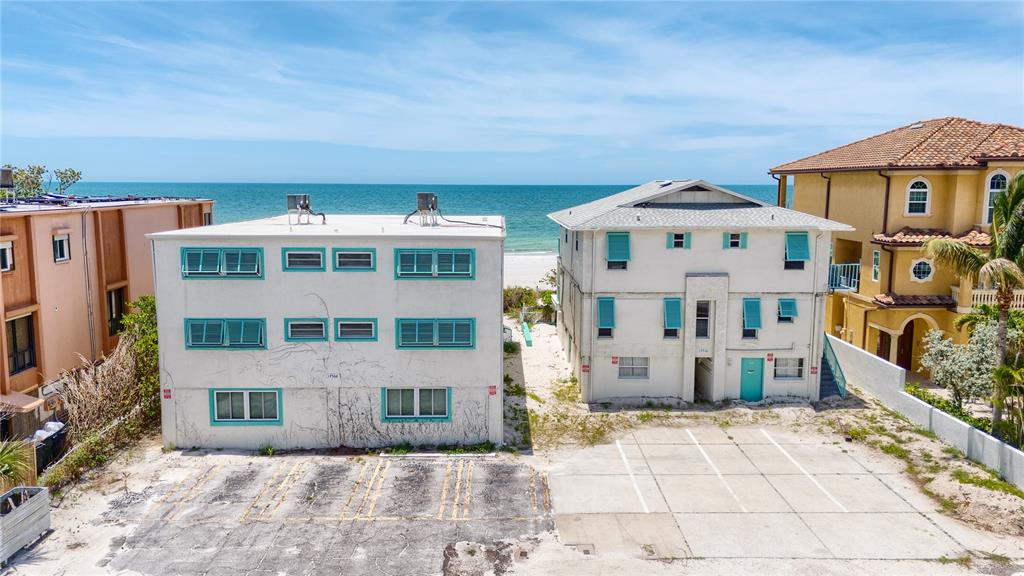 Two multi-story residential buildings sit on a sandy lot facing the ocean — 19306 GULF BOULEVARD, INDIAN ROCKS BEACH, FL