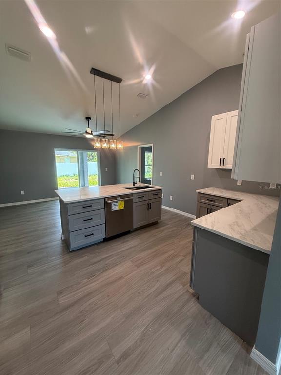 A kitchen with a large island, grey cabinets, white countertops, and wood-look flooring — 2190 PENGUIN LANE, NORTH PORT, FL