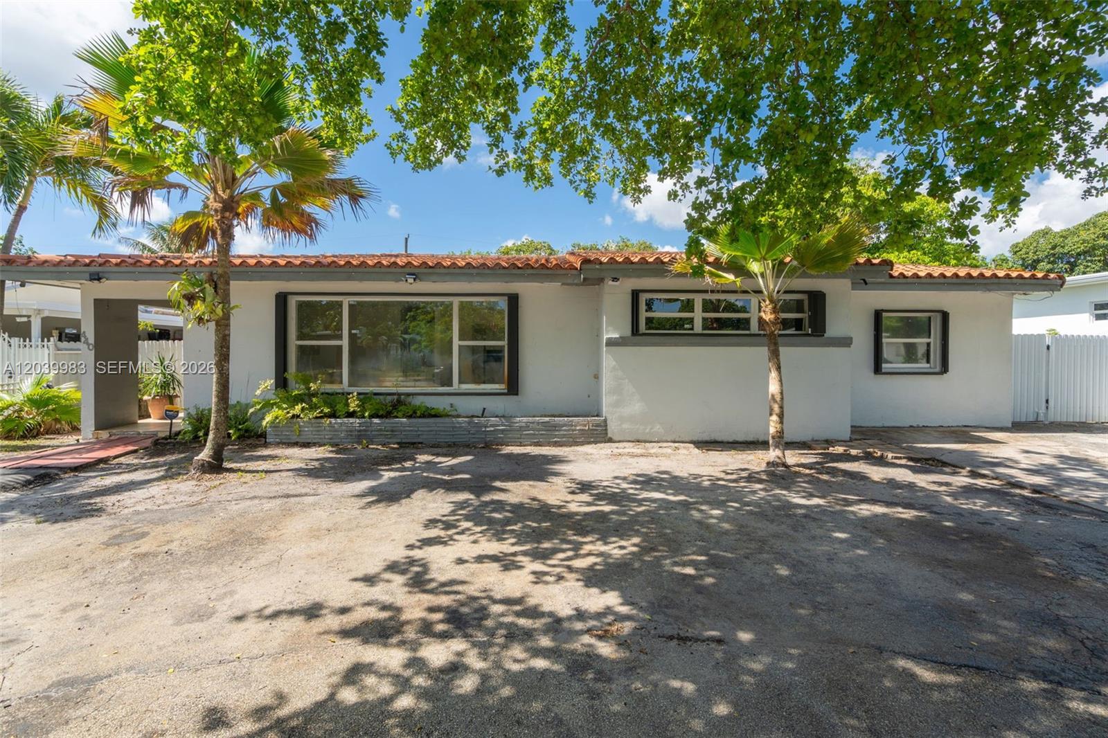 A single-story house with a white exterior, a red tile roof, and a paved driveway — 440 NW 125th St, North Miami FL 33168, NORTH MIAMI, FL