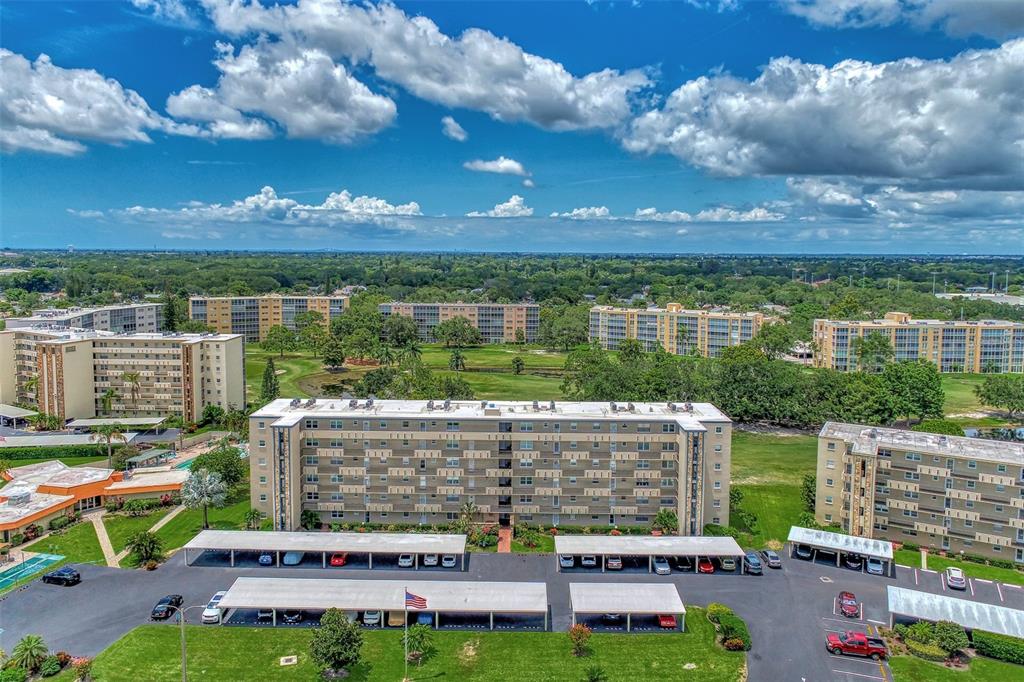 An aerial view shows several multi-story apartment buildings surrounded by green space and parking lots — 3820 IRONWOOD LANE UNIT 603I, BRADENTON, FL