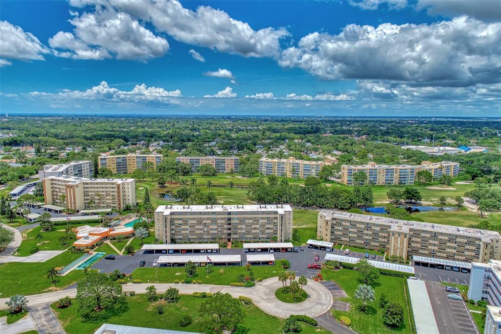 An aerial view shows several multi-story apartment buildings surrounded by green lawns and a golf course — 3820 IRONWOOD LANE UNIT 603I, BRADENTON, FL