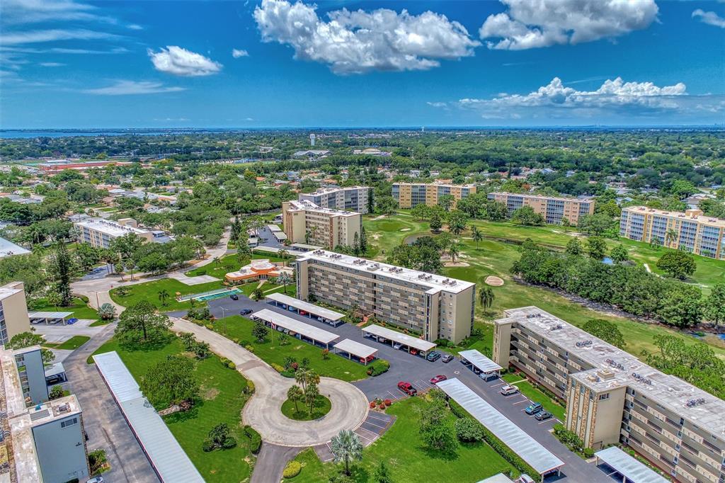 An aerial view shows several multi-story apartment buildings surrounded by green lawns and parking lots — 3820 IRONWOOD LANE UNIT 603I, BRADENTON, FL