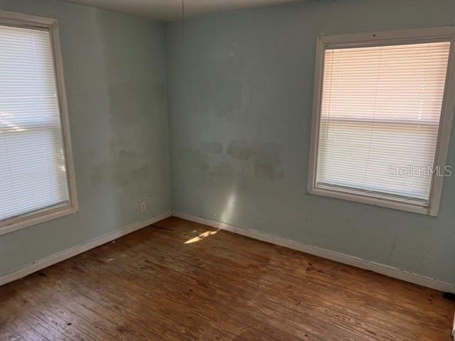 An empty room with light blue walls, wood flooring, and two windows with blinds — 340 PIERCE AVENUE, DAYTONA BEACH, FL