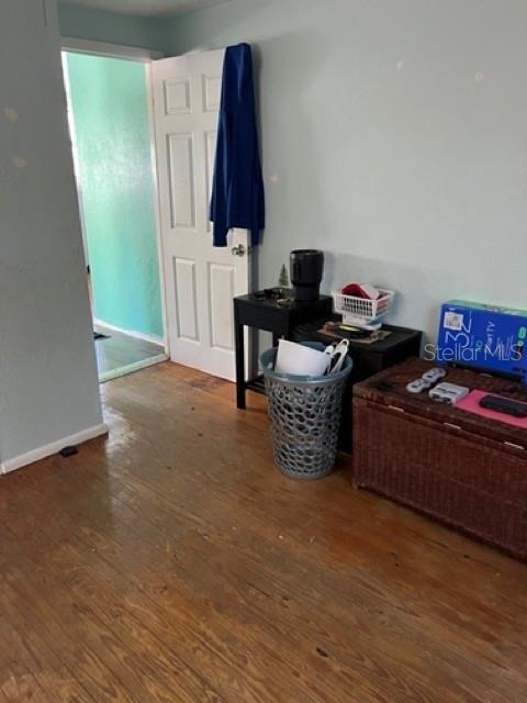 A room with hardwood floors, a white door, a small black table, and a laundry basket — 340 PIERCE AVENUE, DAYTONA BEACH, FL