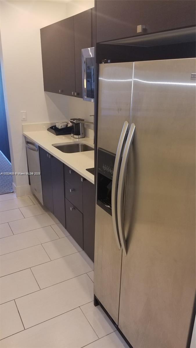 A modern kitchen features dark cabinetry, stainless steel appliances, and white countertops — 5300 NW 87th Ave # 415, Doral FL 33178, DORAL, FL