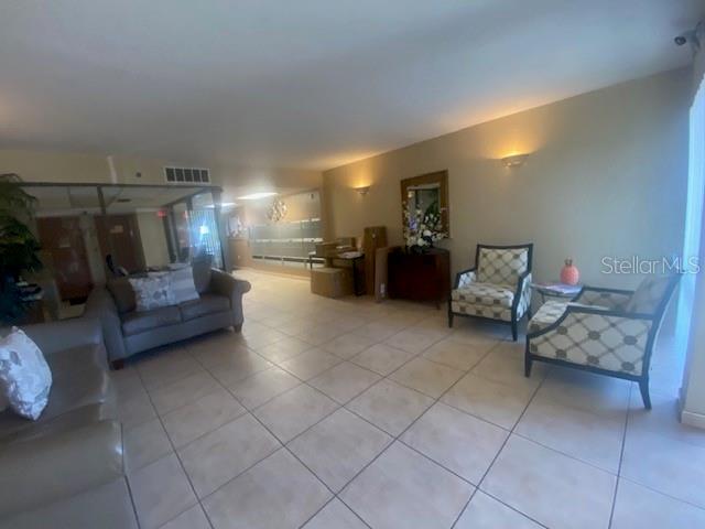 A tiled lobby area features a gray sofa, two patterned armchairs, and mailboxes — 7321 CENTRAL AVENUE UNIT 202, ST PETERSBURG, FL