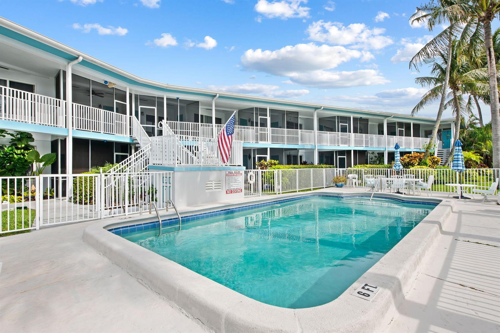 A swimming pool sits in front of a two-story apartment building with white railings — 2748 NE 28th Avenue # 20, Lighthouse Point FL 33064, LIGHTHOUSE POINT, FL