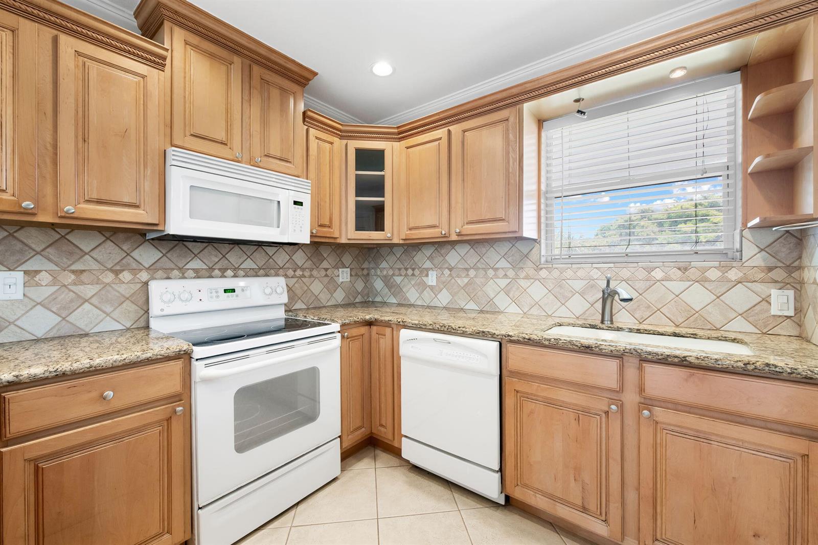 A kitchen features light wood cabinets, granite countertops, white appliances, and a tiled backsplash — 2748 NE 28th Avenue # 20, Lighthouse Point FL 33064, LIGHTHOUSE POINT, FL