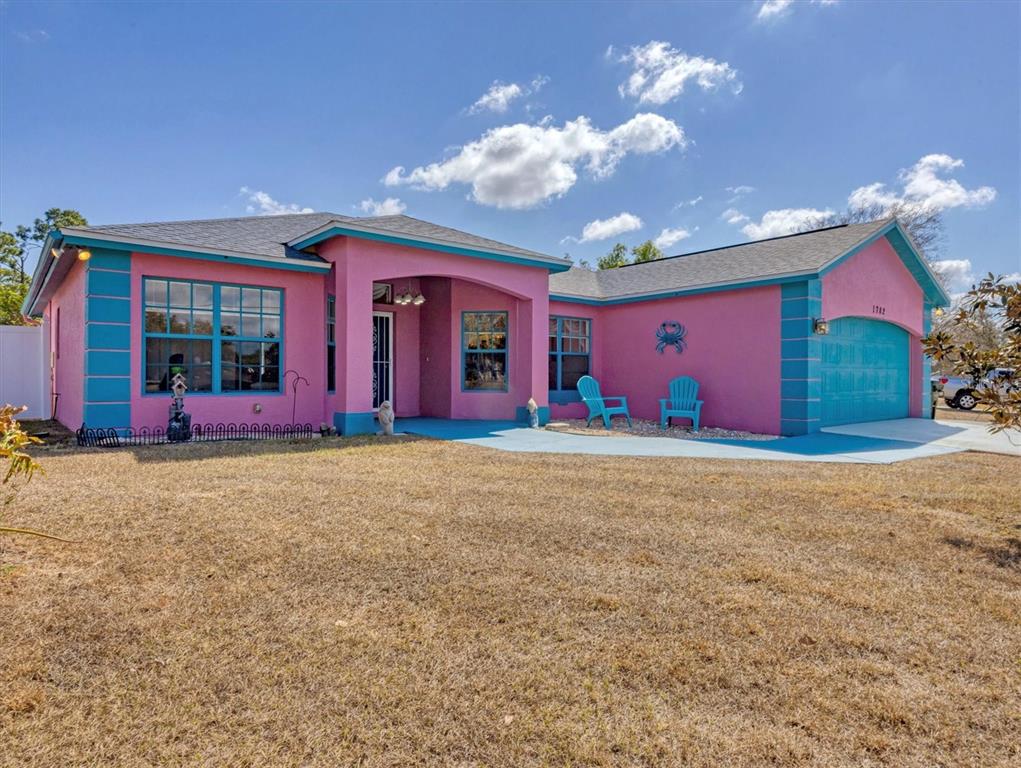 A bright pink single-story house with teal trim and a matching teal garage door — 1782 SHEVLIN STREET, NORTH PORT, FL