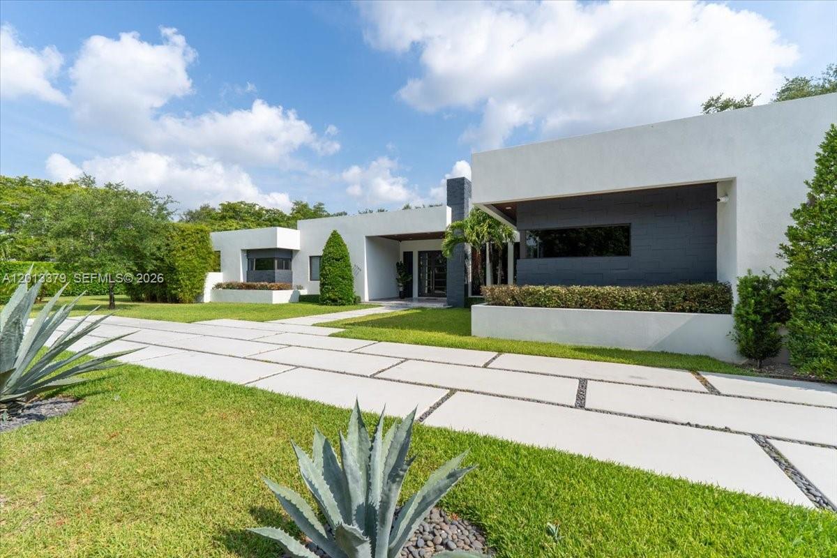 A modern white house with a flat roof and a paved driveway sits on grass — 6785 SW 99th Ter, Pinecrest FL 33156, PINECREST, FL