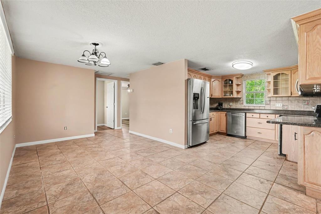 A kitchen and dining area with tile floors, light wood cabinets, and stainless steel appliances — 805 W COLLEGE AVENUE, RUSKIN, FL