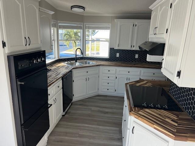 A kitchen features white cabinets, wood countertops, black appliances, and a black hexagonal tile backsplash — 1601 Hwy 441, Okeechobee FL 34974, OKEECHOBEE, FL