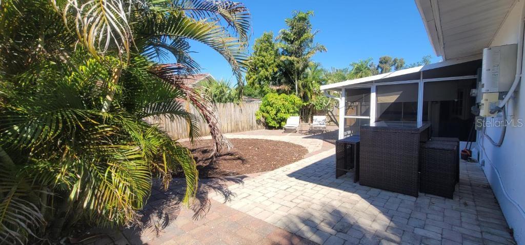 A backyard patio features a paved area, a mulch garden, and a screened-in porch — 3530 SCHWALBE DRIVE, SARASOTA, FL