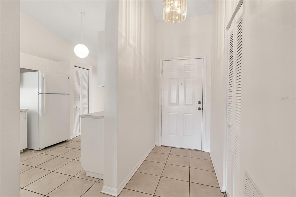 A sunroom with tile flooring, a ceiling fan, and large windows overlooking a lake — 4115 PUTTER PLACE UNIT 4115, BRADENTON, FL
