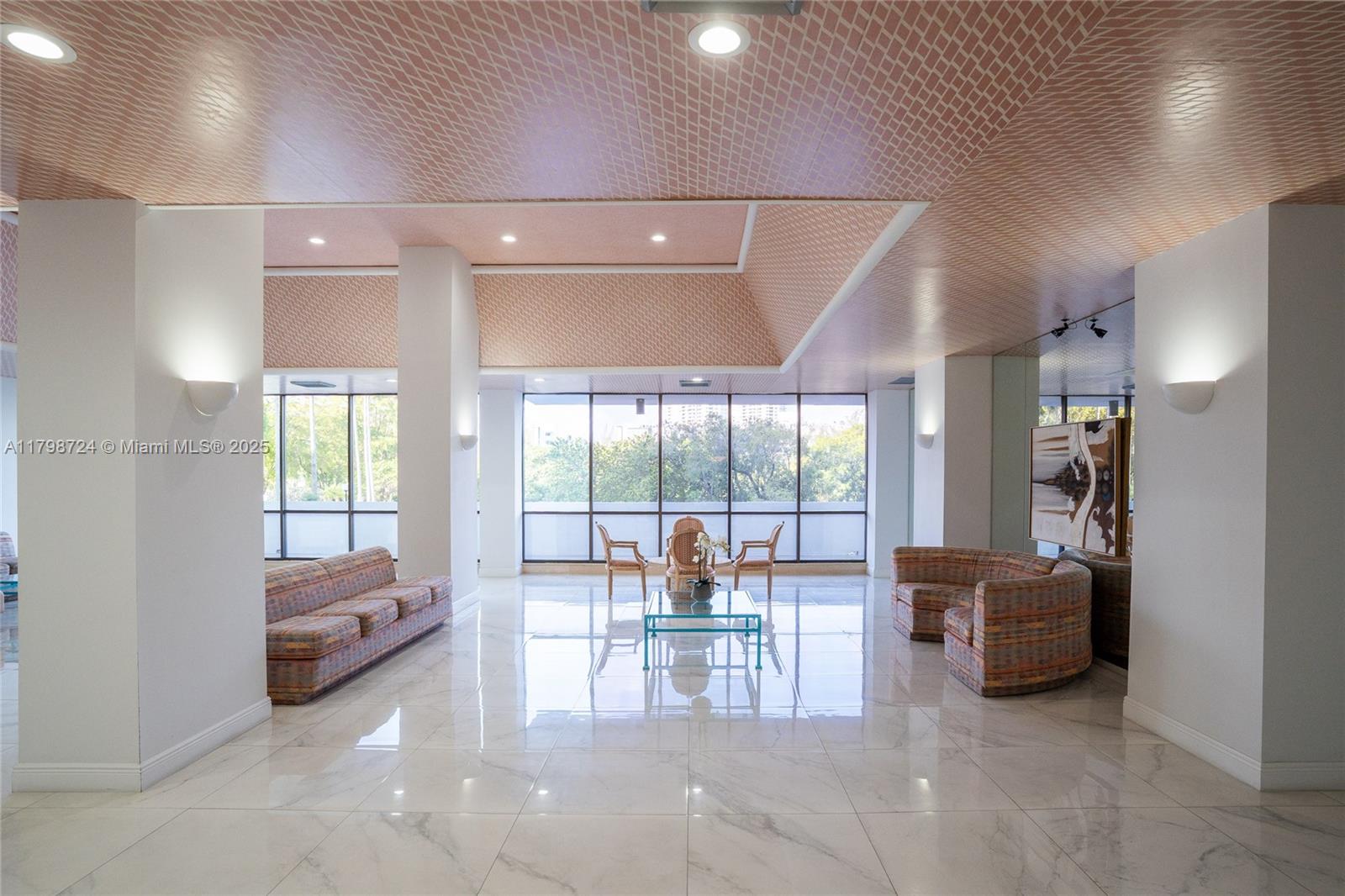 A spacious lobby features white marble floors, patterned ceiling panels, and multiple seating areas — 500 Three Islands Blvd # 801, Hallandale Beach FL 33009, HALLANDALE BEACH, FL