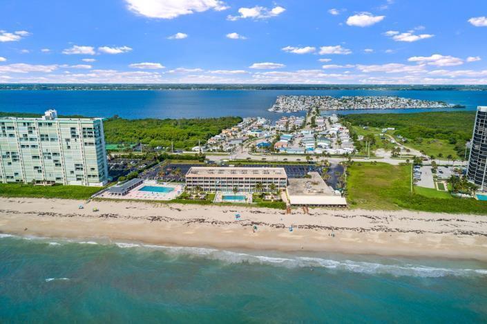 An aerial view shows a beachfront resort building with two pools situated between two high-rises — 9800 S Ocean 107 Drive # 107, Jensen Beach FL 34957, JENSEN BEACH, FL