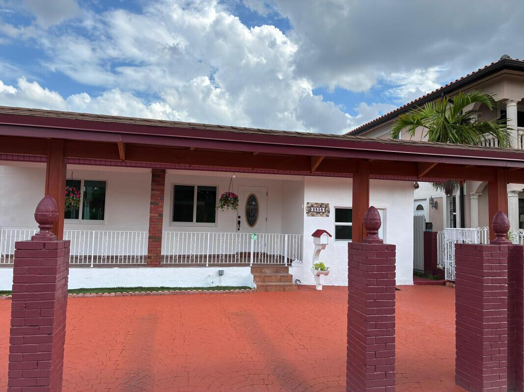 A white house with a red-painted driveway and a covered porch with brick pillars — 2828 SW 2nd Street, Miami FL 33135, MIAMI, FL