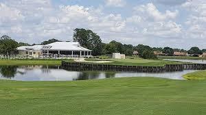A golf course green sits beside a pond with a clubhouse building in the background — 4420 FETTUCCINE AVE, Sebring FL 33872, SEBRING, FL
