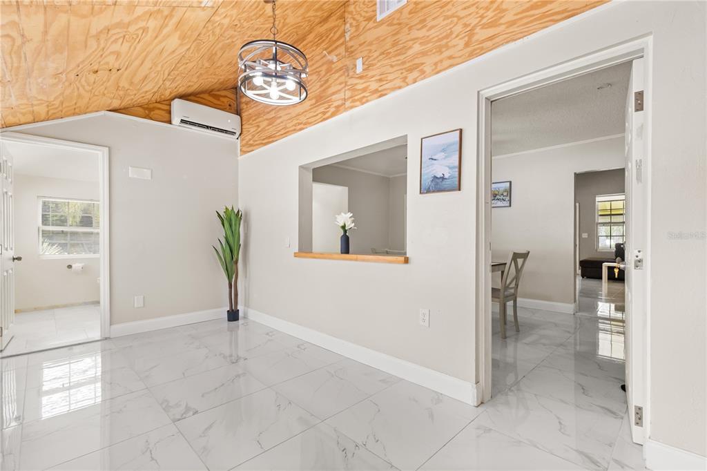 A room with white tile floors, a wood-paneled vaulted ceiling, and a pass-through window — 306 MARSHALL STREET, CLEARWATER, FL