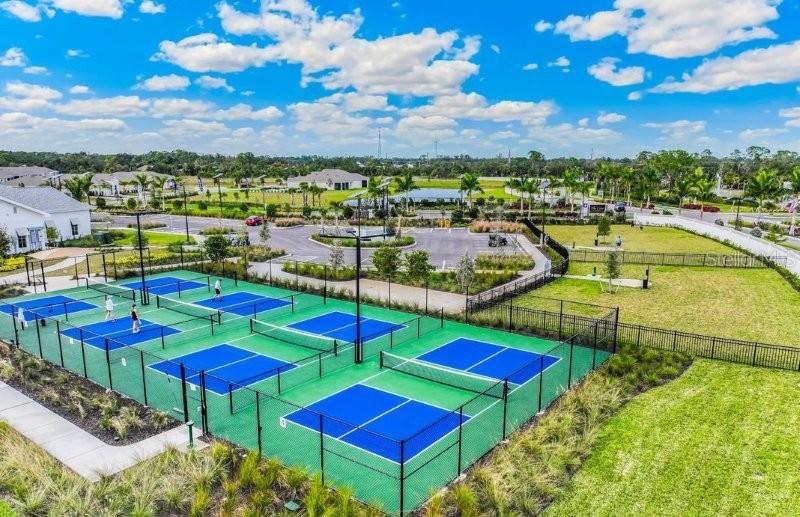 An aerial view shows multiple pickleball courts with blue surfaces and green borders — 16087 IVY RIDGE COURT, PORT CHARLOTTE, FL