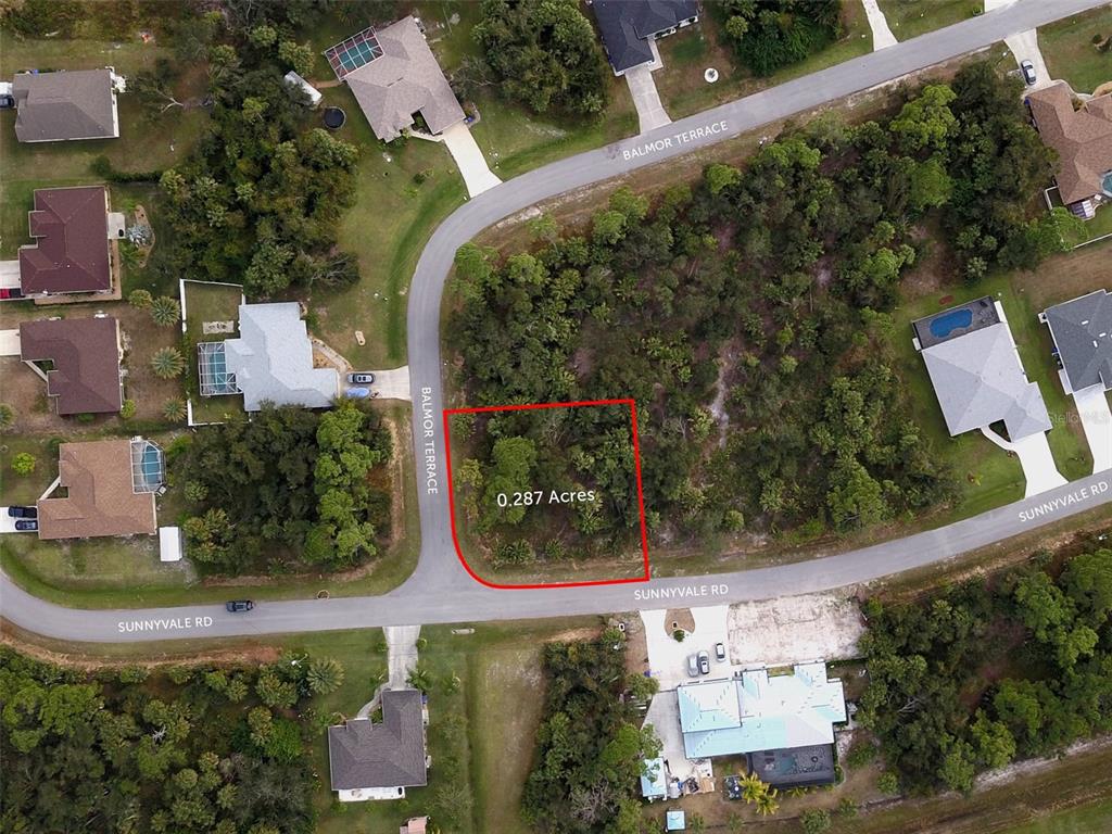 This aerial map shows a vacant residential lot outlined in red at a street intersection — SUNNYVALE ROAD, NORTH PORT, FL